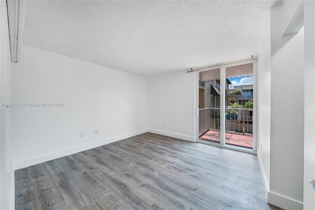 10700 SW 108th Ave Unit C316, Miami, FL 33176 - unfurnished room with a textured ceiling, wood finished floors, and a wall of windows