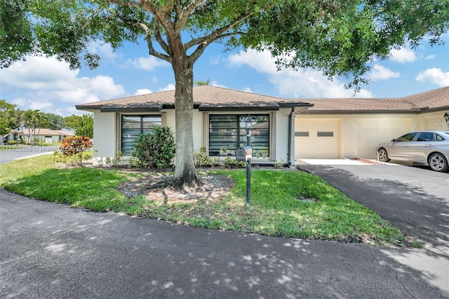 4764 Greentree Cres Unit A, Boynton Beach, FL 33436 - view of front facade with stucco siding, a garage, and asphalt driveway