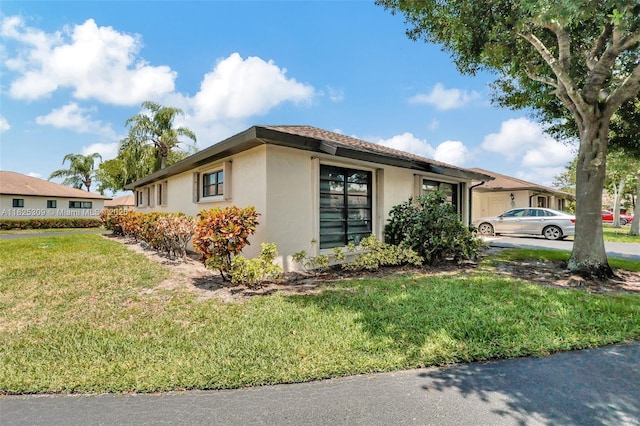 4764 Greentree Cres Unit A, Boynton Beach, FL 33436 - view of home's exterior featuring stucco siding and a yard
