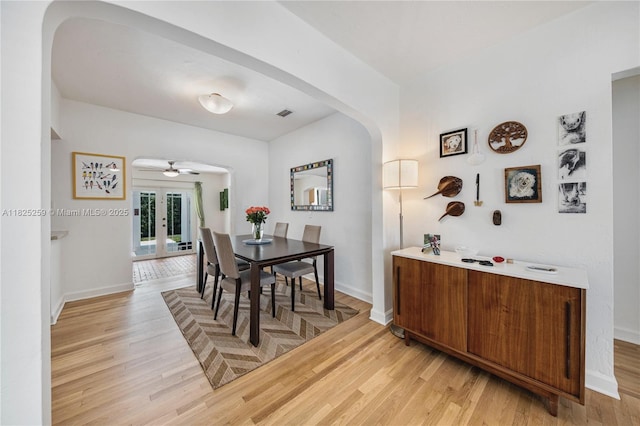 443 SW 18th Rd, Miami, FL 33129 - dining room with arched walkways, light wood-type flooring, french doors, and a ceiling fan