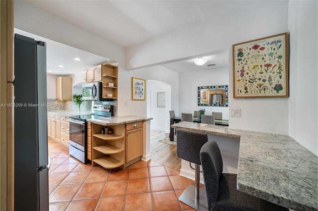 443 SW 18th Rd, Miami, FL 33129 - kitchen with open shelves, appliances with stainless steel finishes, arched walkways, backsplash, and light tile patterned flooring
