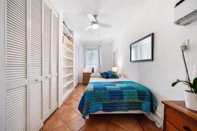443 SW 18th Rd, Miami, FL 33129 - bedroom with a closet, a wall mounted air conditioner, light tile patterned floors, a textured ceiling, and a ceiling fan