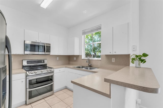 8081 NW 107th Ct, Doral, FL 33178 - kitchen featuring appliances with stainless steel finishes, a peninsula, backsplash, white cabinets, and light countertops