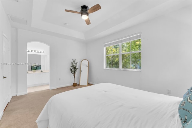 8081 NW 107th Ct, Doral, FL 33178 - bedroom featuring light colored carpet, a tray ceiling, connected bathroom, and a ceiling fan