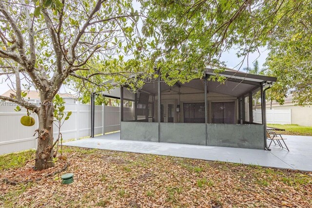 3420 NW 21st Ct, Coconut Creek, FL 33066 - rear view of property featuring a sunroom, a fenced backyard, and a patio area