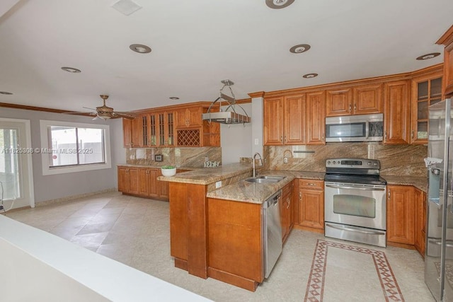 3420 NW 21st Ct, Coconut Creek, FL 33066 - kitchen featuring stainless steel appliances, brown cabinetry, a peninsula, ornamental molding, and recessed lighting