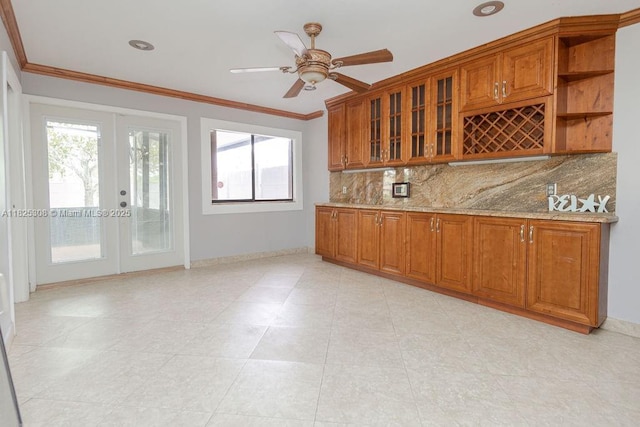 3420 NW 21st Ct, Coconut Creek, FL 33066 - kitchen featuring brown cabinetry, tasteful backsplash, healthy amount of natural light, crown molding, and light stone countertops