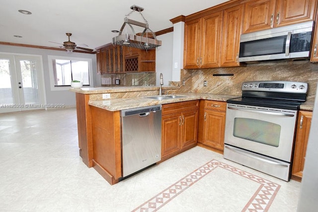 3420 NW 21st Ct, Coconut Creek, FL 33066 - kitchen featuring appliances with stainless steel finishes, ornamental molding, a peninsula, brown cabinets, and decorative backsplash