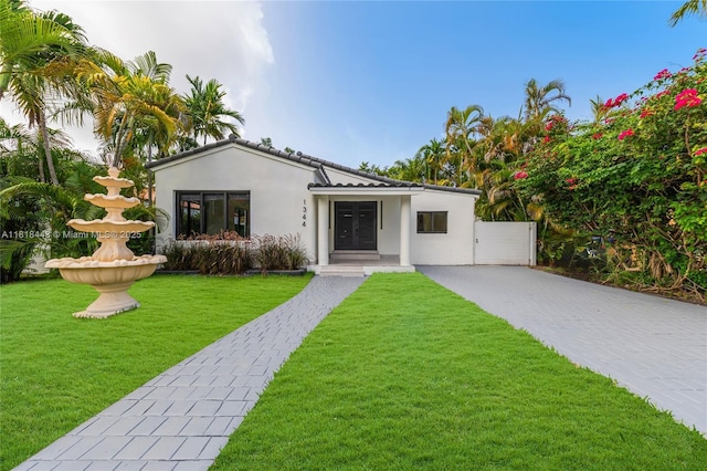 1344 SW 18th St, Miami, FL 33145 - view of front of property with stucco siding, decorative driveway, a front lawn, and a gate