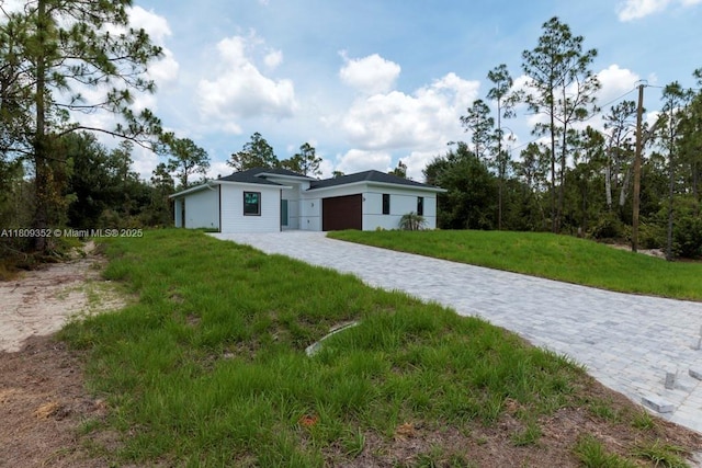 719 Almelia St E, Lehigh Acres, FL 33974 - view of front facade with an attached garage, a front yard, and driveway