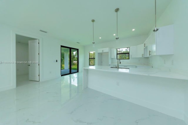719 Almelia St E, Lehigh Acres, FL 33974 - kitchen featuring white cabinetry, a peninsula, light marble finish flooring, recessed lighting, and french doors