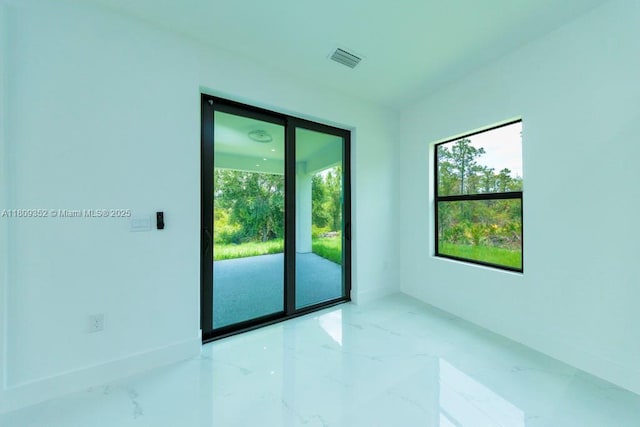 719 Almelia St E, Lehigh Acres, FL 33974 - empty room featuring marble tiled flooring and plenty of natural light