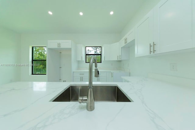 719 Almelia St E, Lehigh Acres, FL 33974 - kitchen with light stone counters, recessed lighting, and white cabinets