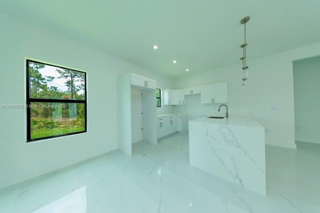 719 Almelia St E, Lehigh Acres, FL 33974 - kitchen featuring white cabinetry, light marble finish floors, recessed lighting, decorative light fixtures, and light stone counters