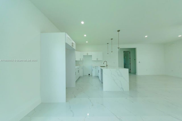 719 Almelia St E, Lehigh Acres, FL 33974 - kitchen with recessed lighting, white cabinets, light marble finish flooring, open floor plan, and pendant lighting