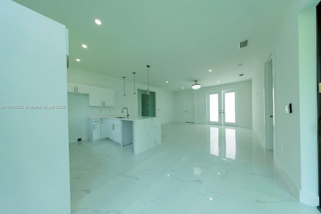 719 Almelia St E, Lehigh Acres, FL 33974 - unfurnished living room featuring french doors, recessed lighting, and light marble finish flooring