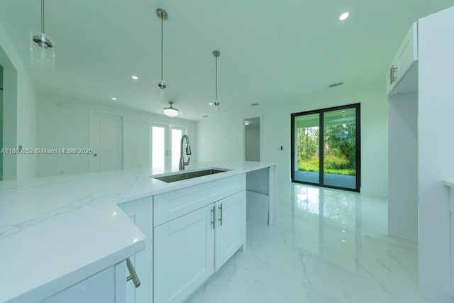 719 Almelia St E, Lehigh Acres, FL 33974 - kitchen with light stone countertops, white cabinets, french doors, recessed lighting, and open floor plan