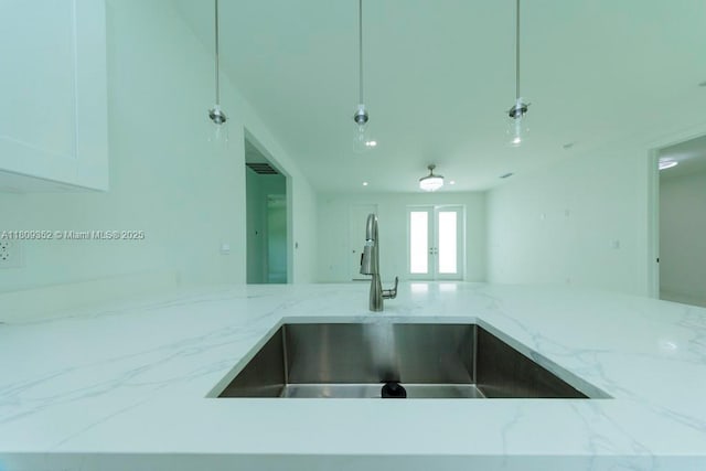719 Almelia St E, Lehigh Acres, FL 33974 - kitchen featuring light stone countertops and french doors