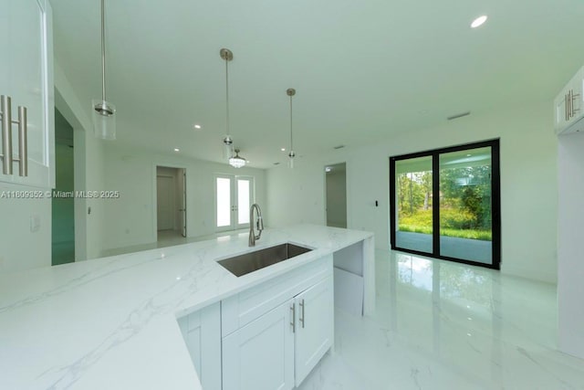 719 Almelia St E, Lehigh Acres, FL 33974 - kitchen with open floor plan, light stone counters, white cabinetry, french doors, and recessed lighting