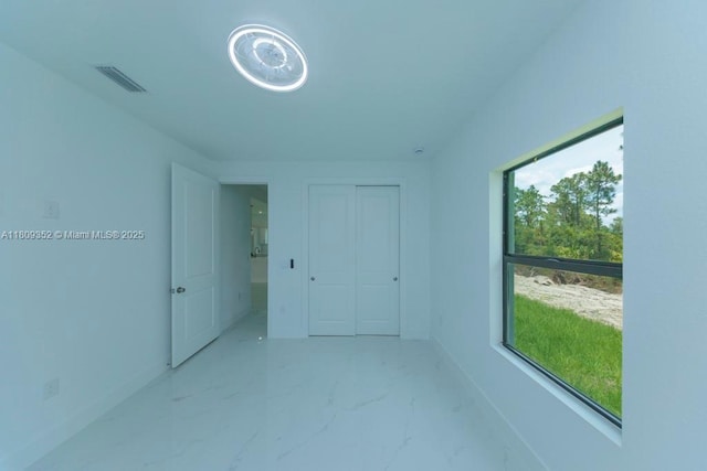719 Almelia St E, Lehigh Acres, FL 33974 - spare room featuring baseboards and light marble finish flooring