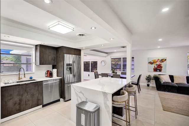 3338 Cleveland St, Hollywood, FL 33021 - kitchen with stainless steel appliances, a breakfast bar area, dark brown cabinets, recessed lighting, and light tile patterned flooring