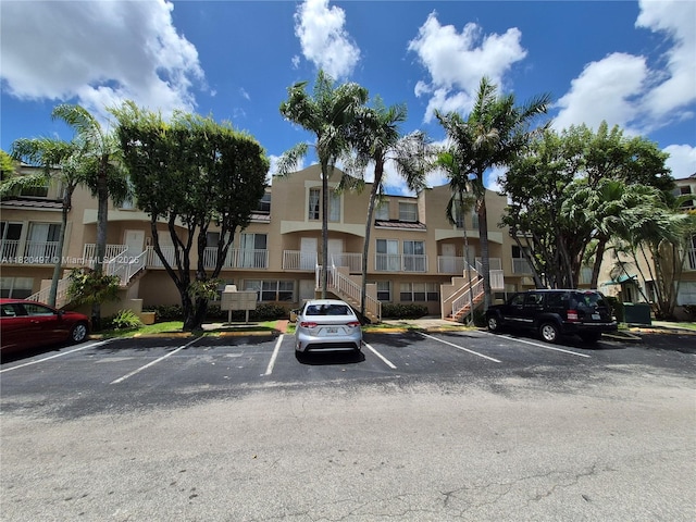8660 NW 6th Ln Unit 5-206, Miami, FL 33126 - view of building exterior with uncovered parking, a residential view, and stairs