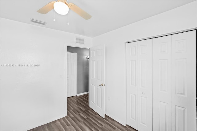 2818 W 66th St, Lehigh Acres, FL 33971 - unfurnished bedroom with dark wood-type flooring, a closet, and a ceiling fan