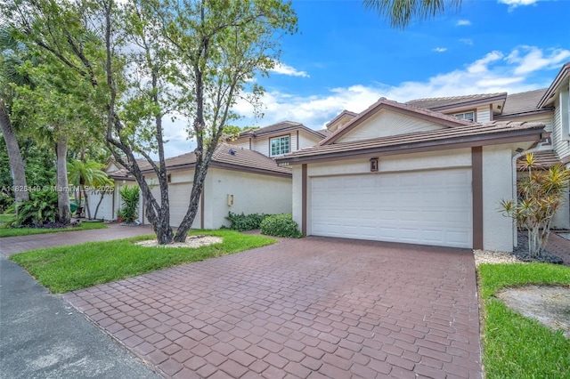 11664 NW 19th Dr, Coral Springs, FL 33071 - view of front facade with decorative driveway, stucco siding, a tile roof, and an attached garage