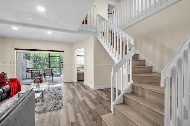 11664 NW 19th Dr, Coral Springs, FL 33071 - living area featuring a textured ceiling, wood finished floors, stairway, and recessed lighting