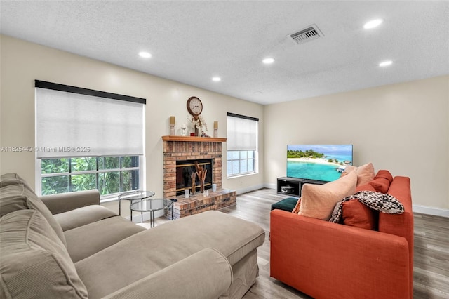 11664 NW 19th Dr, Coral Springs, FL 33071 - living room featuring healthy amount of natural light, recessed lighting, a brick fireplace, wood finished floors, and a textured ceiling