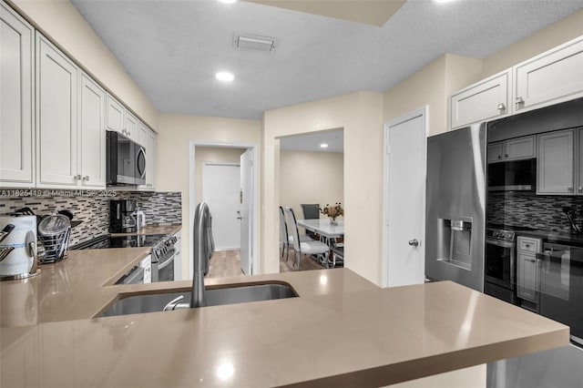 11664 NW 19th Dr, Coral Springs, FL 33071 - kitchen with stainless steel appliances, backsplash, recessed lighting, light countertops, and a textured ceiling