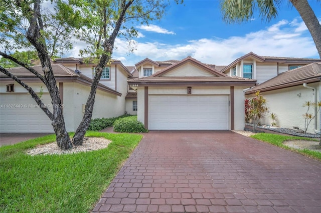 11664 NW 19th Dr, Coral Springs, FL 33071 - traditional-style home featuring stucco siding, decorative driveway, an attached garage, and a tile roof