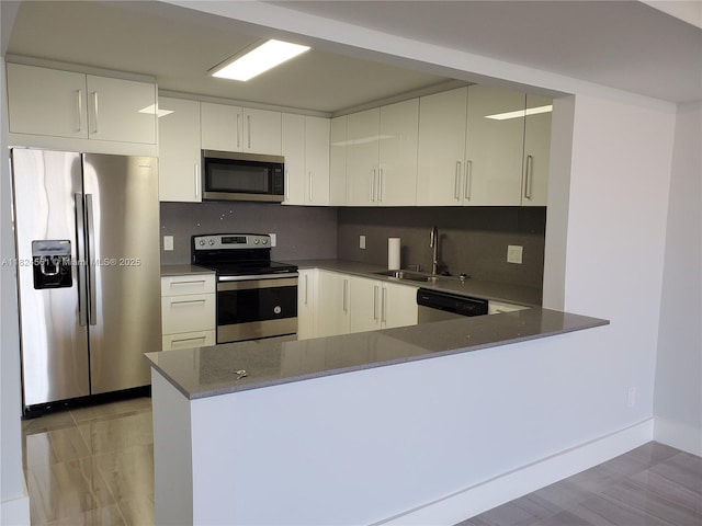 13499 Biscayne Blvd Unit 1105, North Miami, FL 33181 - kitchen featuring appliances with stainless steel finishes, a peninsula, decorative backsplash, and white cabinets