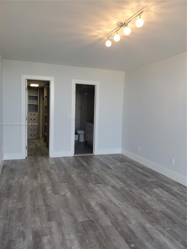 13499 Biscayne Blvd Unit 1105, North Miami, FL 33181 - unfurnished bedroom with wood finished floors, a walk in closet, connected bathroom, track lighting, and a closet