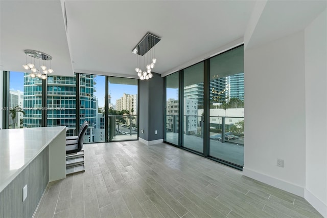 2900 NE 7th Ave Unit 301, Miami, FL 33137 - unfurnished room with a chandelier, a city view, floor to ceiling windows, and light wood-style floors