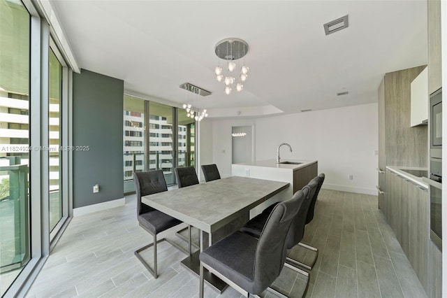 2900 NE 7th Ave Unit 301, Miami, FL 33137 - dining space with a chandelier, plenty of natural light, and light wood finished floors