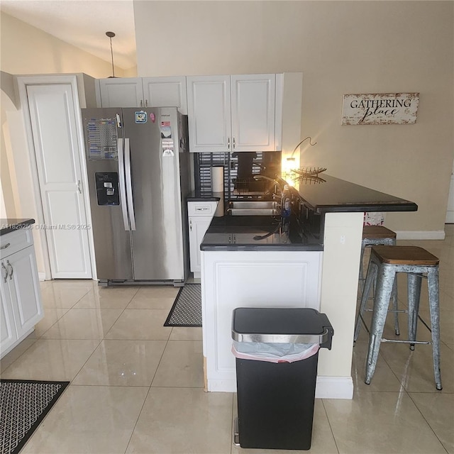 2017 NW 182nd Ave, Pembroke Pines, FL 33029 - kitchen featuring stainless steel fridge, dark countertops, a kitchen breakfast bar, white cabinets, and tasteful backsplash
