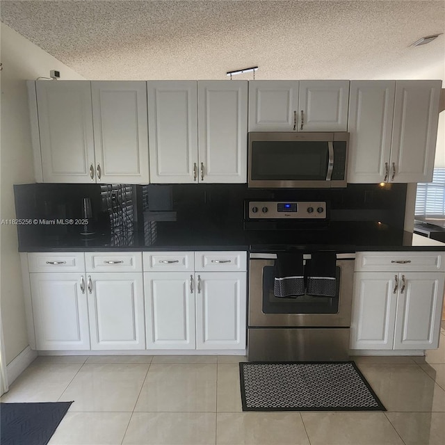 2017 NW 182nd Ave, Pembroke Pines, FL 33029 - kitchen with stainless steel appliances, dark countertops, a textured ceiling, decorative backsplash, and white cabinetry