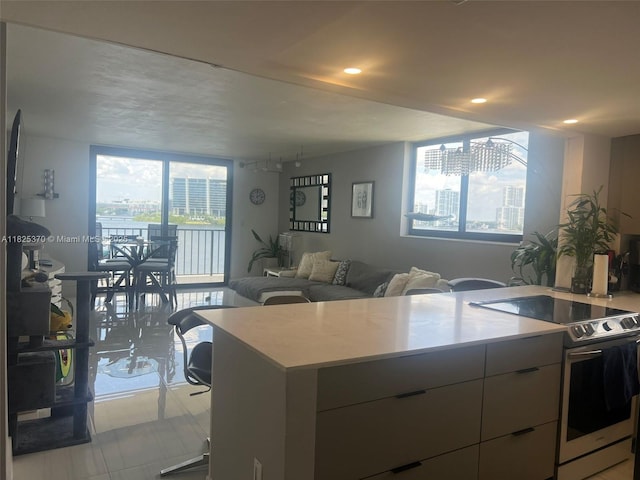 17878 N Bay Rd Unit 507, Sunny Isles Beach, FL 33160 - kitchen featuring white range with electric stovetop, modern cabinets, light countertops, plenty of natural light, and recessed lighting