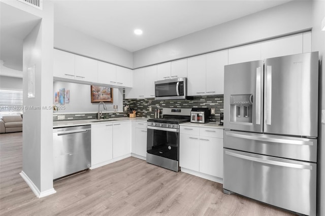 11000 Sand Piper Ct, Tamarac, FL 33321 - kitchen featuring stainless steel appliances, light countertops, light wood finished floors, decorative backsplash, and recessed lighting
