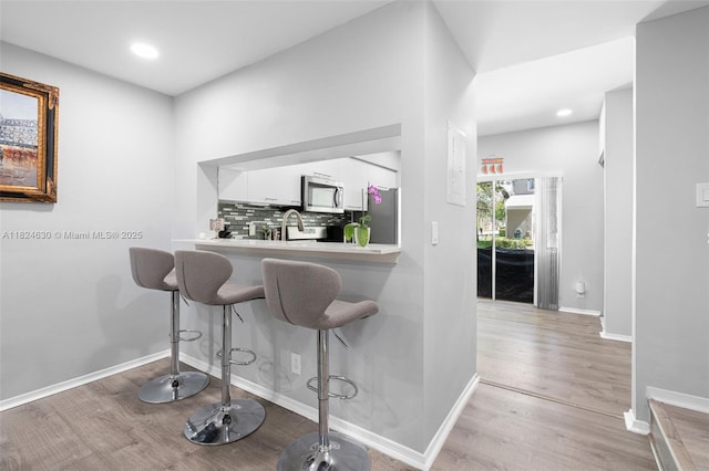 11000 Sand Piper Ct, Tamarac, FL 33321 - bar with stainless steel appliances, light wood-style flooring, backsplash, and recessed lighting