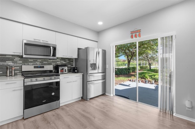 11000 Sand Piper Ct, Tamarac, FL 33321 - kitchen featuring appliances with stainless steel finishes, light countertops, tasteful backsplash, light wood-style floors, and white cabinets