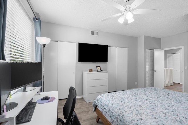 11000 Sand Piper Ct, Tamarac, FL 33321 - bedroom with multiple closets, light wood-style floors, a textured ceiling, an office area, and a ceiling fan