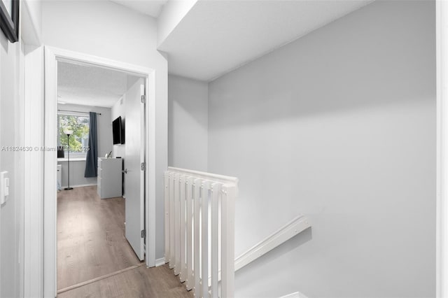 11000 Sand Piper Ct, Tamarac, FL 33321 - hallway featuring wood finished floors, radiator, an upstairs landing, and a textured ceiling