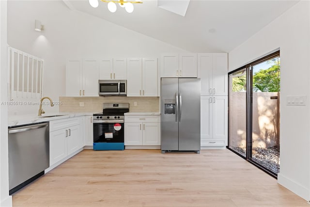 7720 NW 79th Ave Unit B6, Tamarac, FL 33321 - kitchen with appliances with stainless steel finishes, decorative backsplash, light wood-style flooring, white cabinets, and light stone countertops
