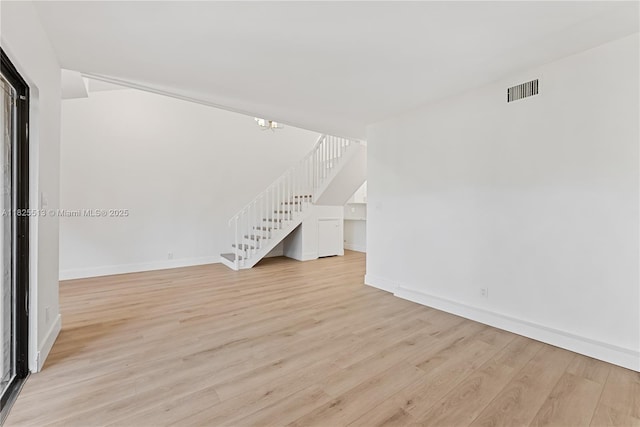 7720 NW 79th Ave Unit B6, Tamarac, FL 33321 - spare room with stairs, light wood-type flooring, and a chandelier