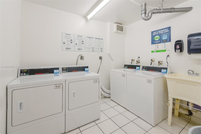 1020 Meridian Ave Unit 816, Miami Beach, FL 33139 - shared laundry featuring washing machine and dryer and light tile patterned flooring