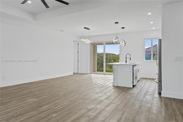 10071 Kingsville Prt, Charlotte, FL 33981 - kitchen featuring stainless steel appliances, light countertops, ceiling fan, light wood-style flooring, and decorative light fixtures