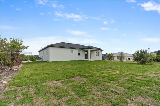 10071 Kingsville Prt, Charlotte, FL 33981 - rear view of house with stucco siding and a yard