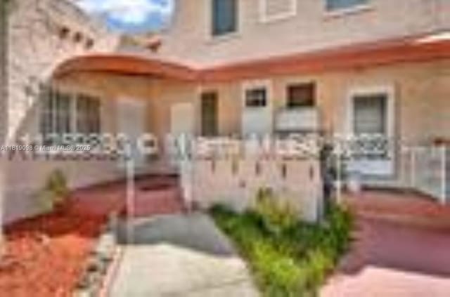 829 SW 19th Ave, Miami, FL 33135 - view of front of home with a fenced front yard, a gate, covered porch, and stucco siding